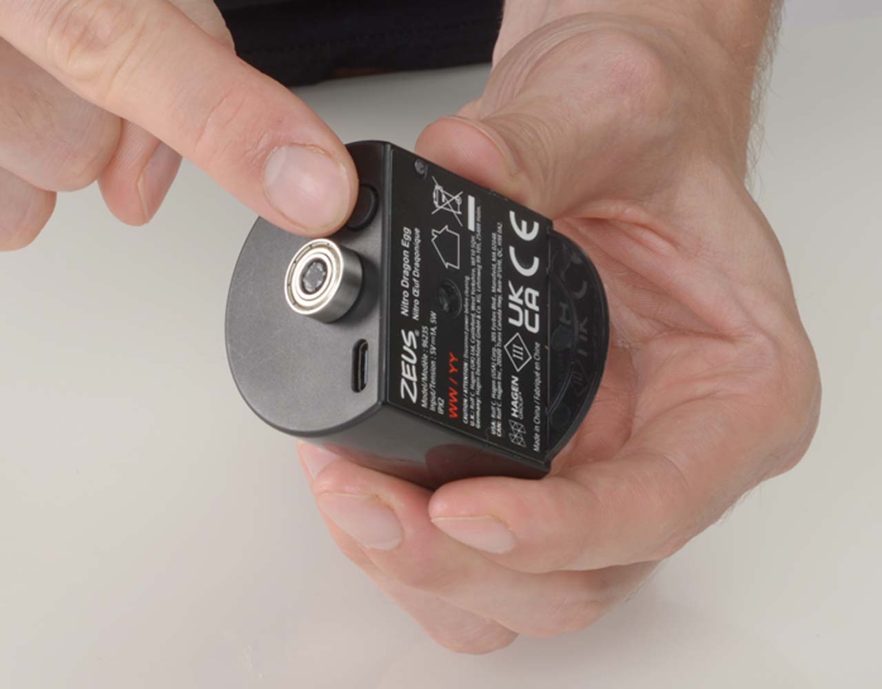 Hand pushing the button on the Zeus NITRO Dragon Egg motor hub.