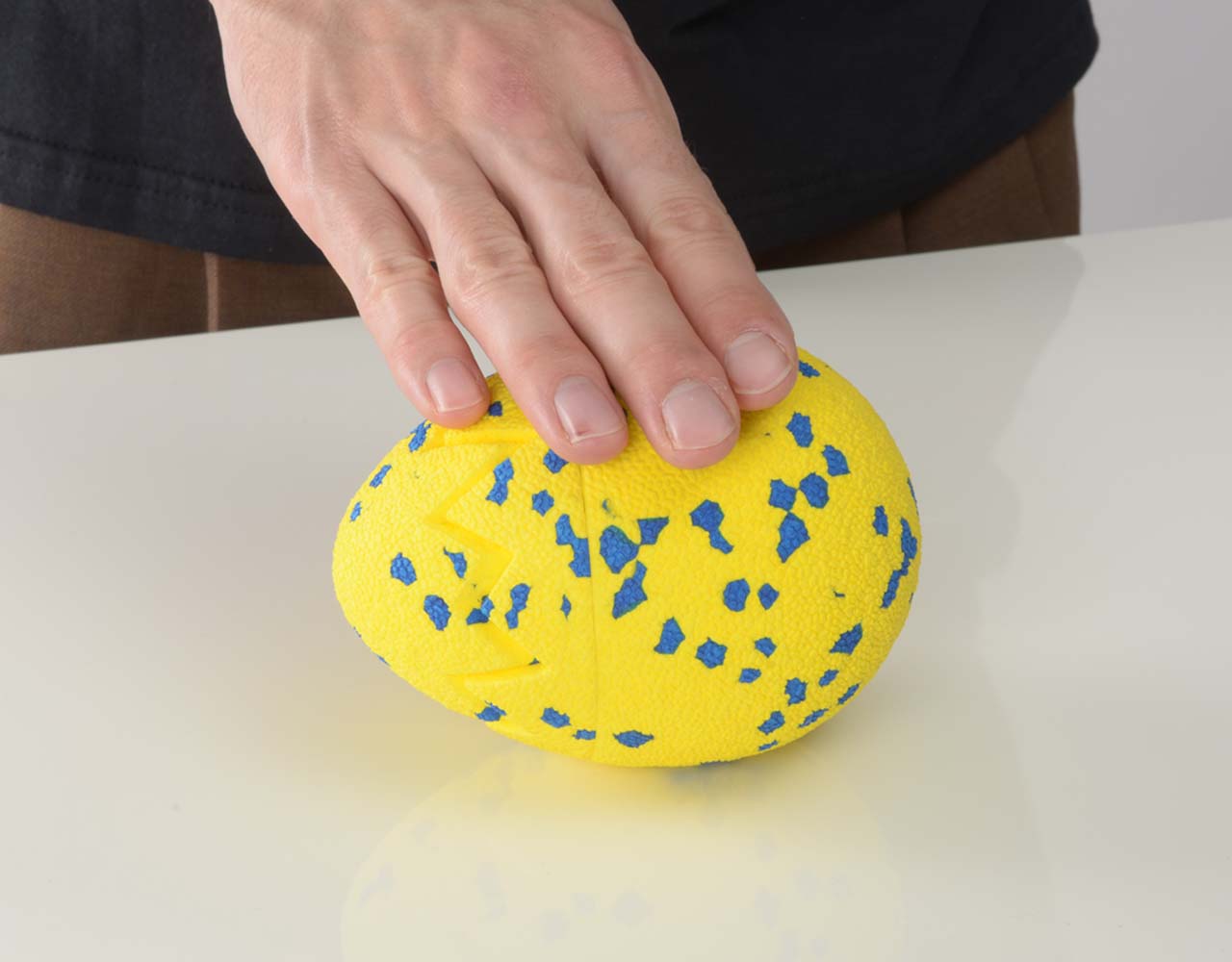 Hand tapping the Zeus NITRO Dragon Egg while it is laying still on a flat surface.