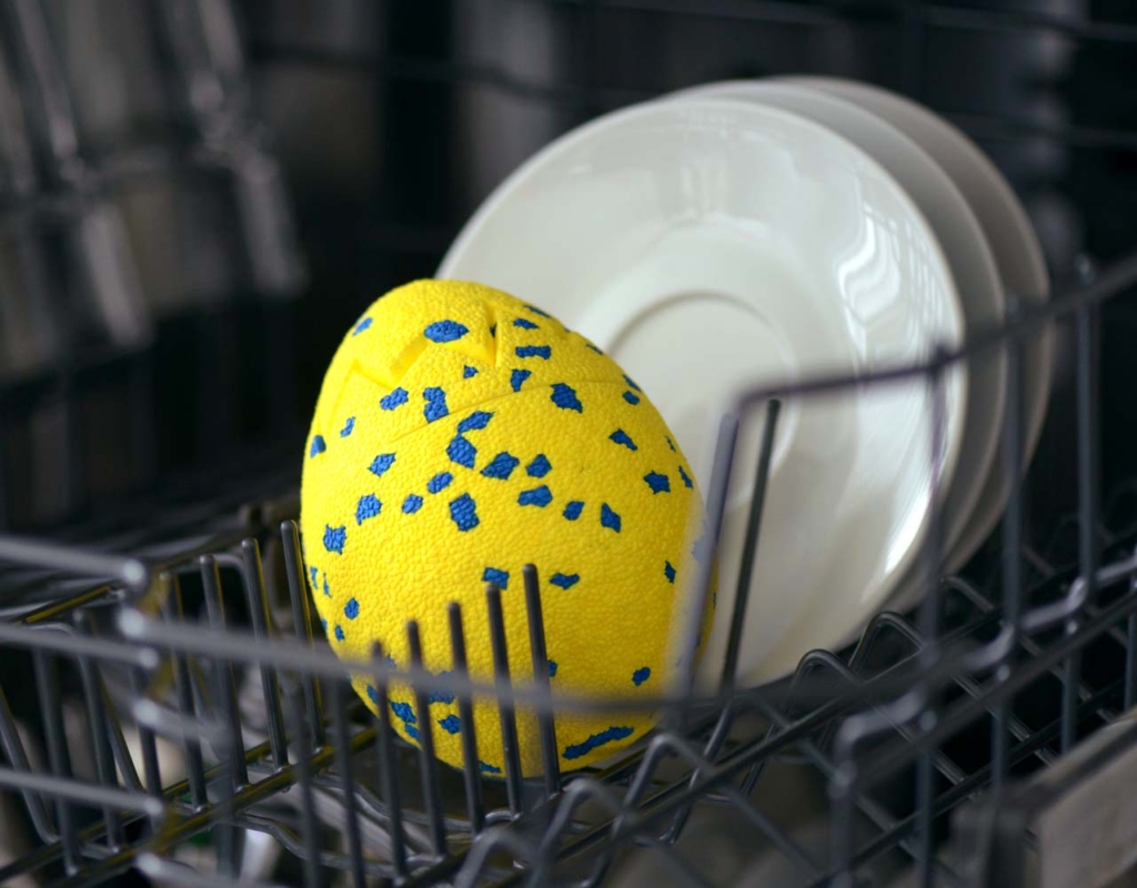The Zeus NITRO Dragon Egg sitting in a dishwasher next to some small plates.